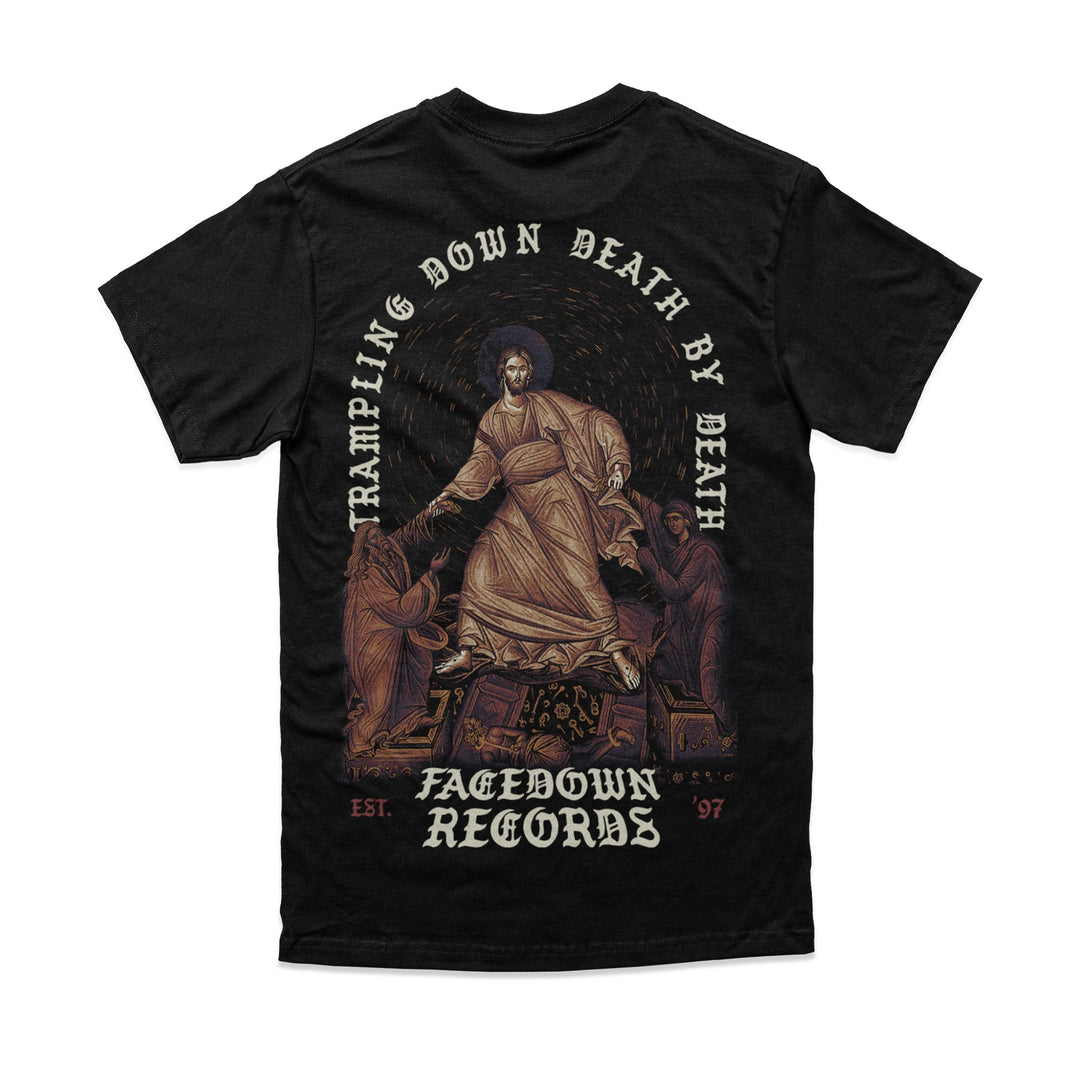 Black Comfort Colors t-shirt by Facedown Records with a robed figure trampling skulls, flanked by two figures. “Trampling Down Death By Death” is above and “Facedown Records Est. ’97” is printed below.
