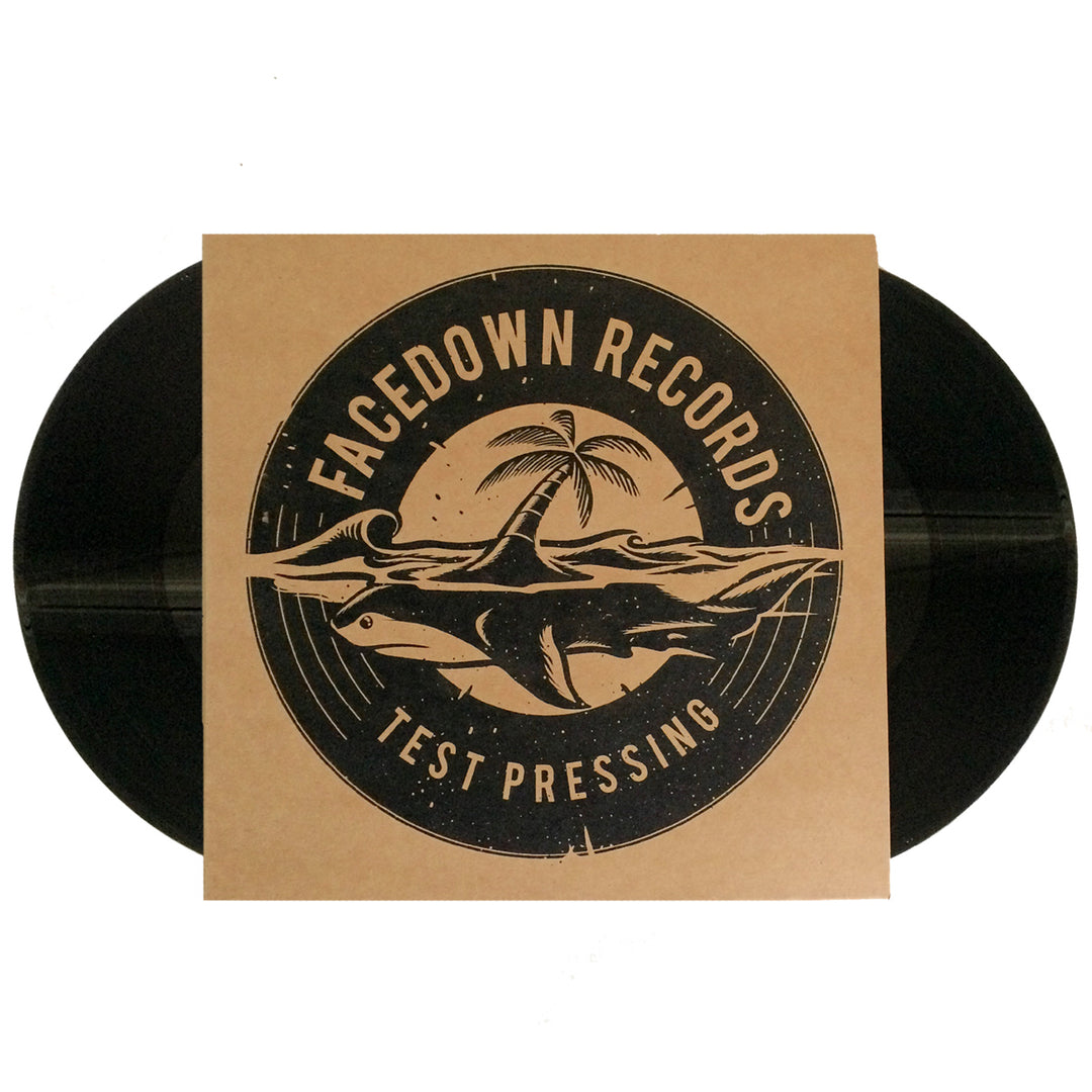 A black vinyl by HolyName is partially covered by a brown sleeve with the Facedown Records logo—palm tree, waves, shark—and Facedown Records Test Pressing, referencing HolyName’s Rock Against Traffic.