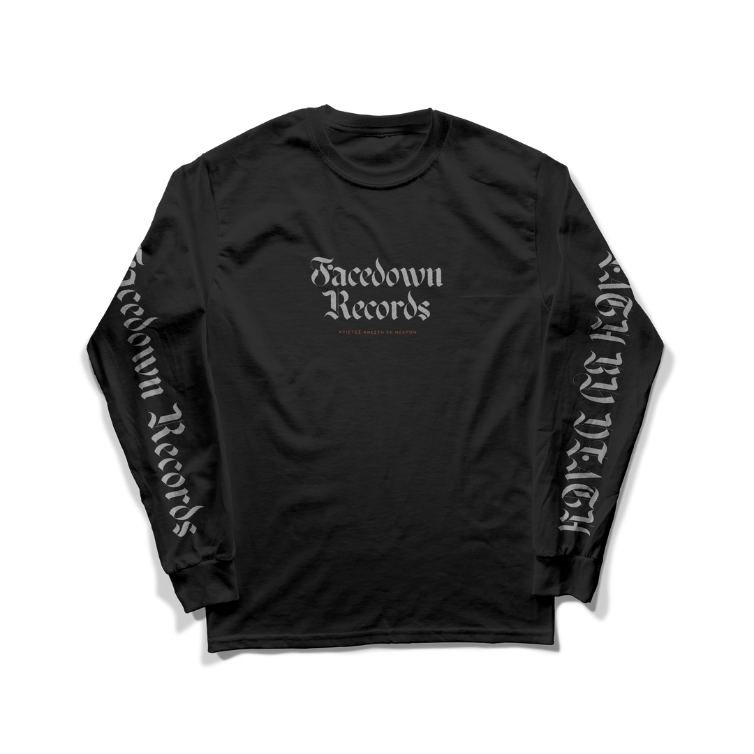 A black Facedown Records long sleeve shirt with gothic logo on chest and sleeves, red text below the logo, displayed on white. Part of the More Than Sound charity program. American Apparel brand.