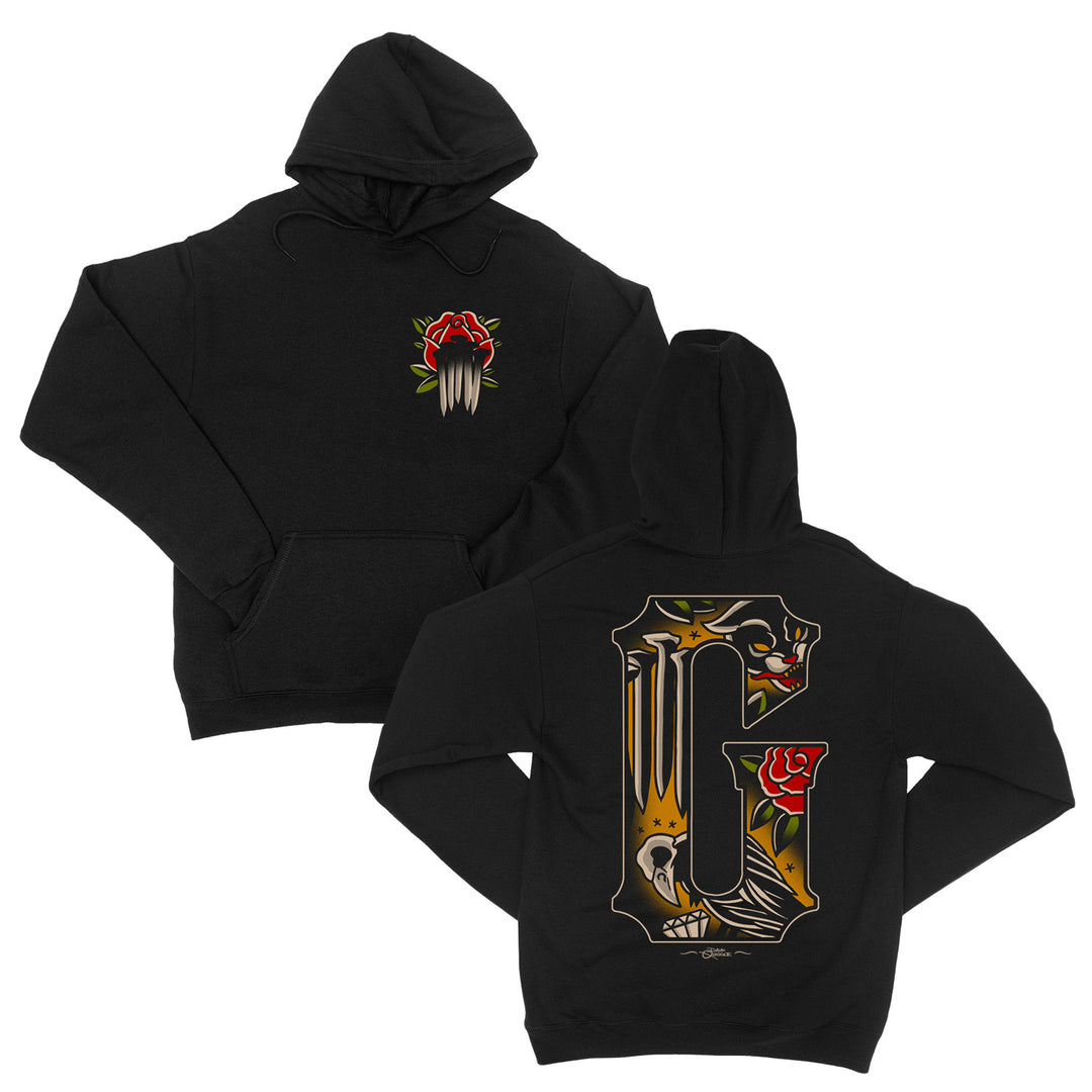 Black pullover hoodie with a small rose and claw graphic on the front left chest, and a large ornate G with skull, rose, and bird design on the back. Classic fit Gildan Heavy Blend for comfort and style.