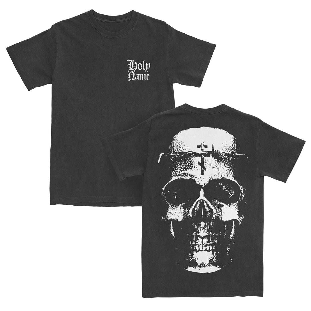 Black t-shirt crafted from premium ring-spun cotton with Holy Name in white gothic font on the front left chest, and a large grayscale skull graphic with a cross on the forehead printed on the back. Featuring a modern classic fit inspired by Gildan Softstyle T-Shirts, this piece blends comfort with bold style.