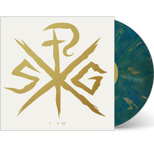 A limited edition Sleeping Giant vinyl in the Royal Kingdom blue-green marble partially slides from its cover. The white sleeve shows a bold gold abstract emblem and "I AM" at the bottom.