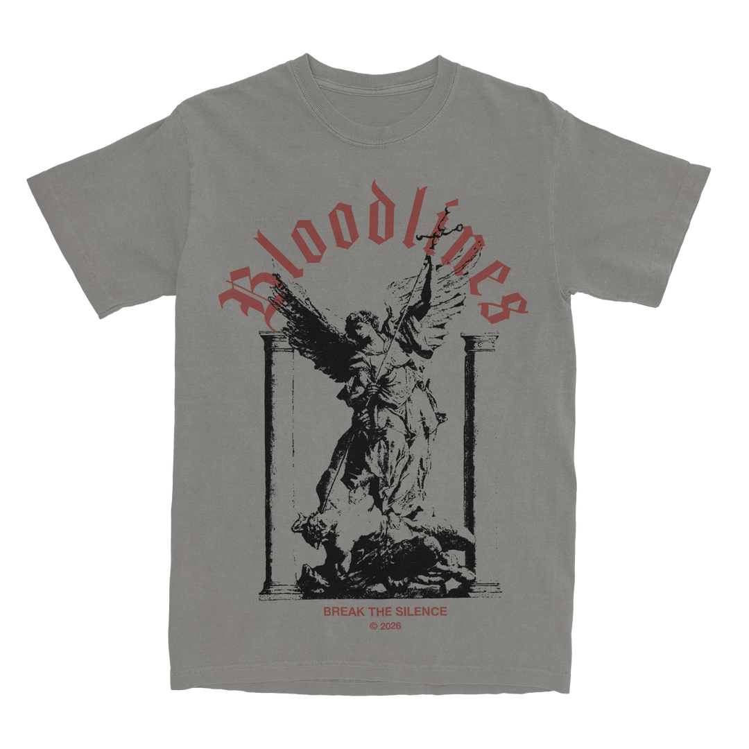 Gray heavyweight t-shirt with a black graphic of an angel statue between two pillars. Red text above reads Bloodlines. Below the image, small red text says Break the Silence © 2023. Crafted from premium ring-spun cotton for added comfort and durability.