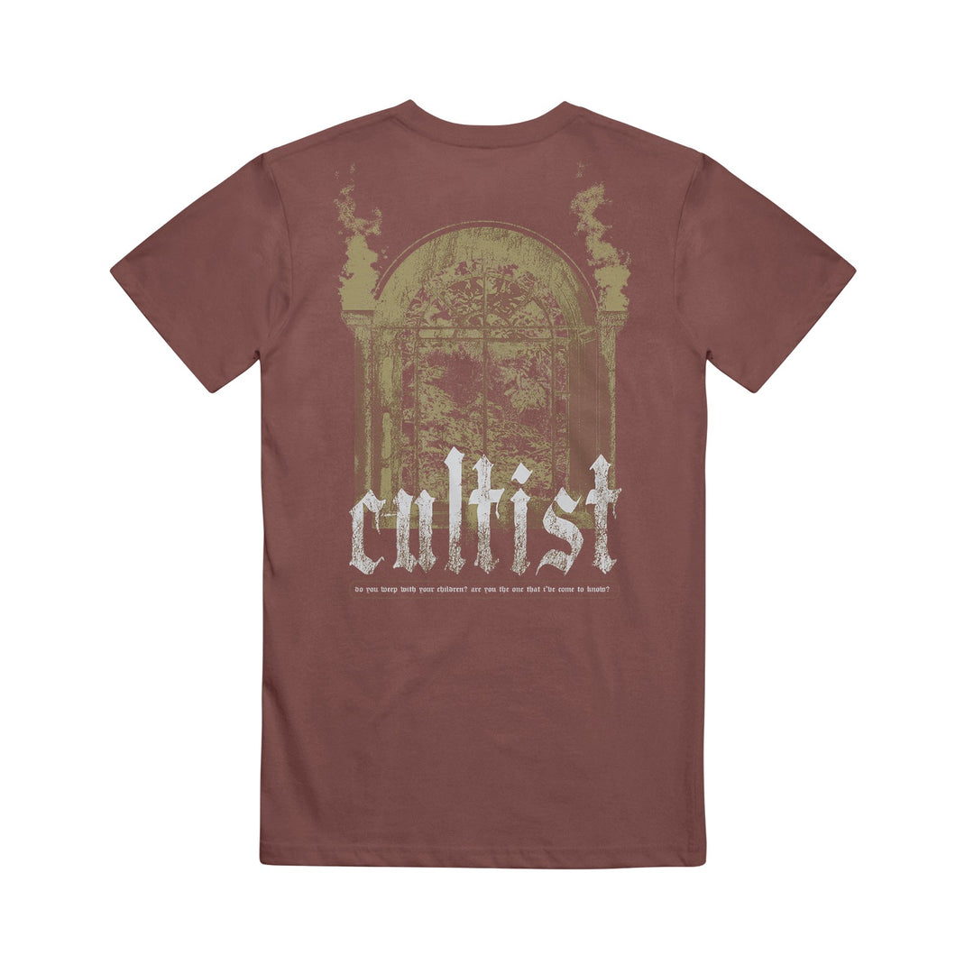 A brown Cultist Comfort Colors shirt with a faded, vintage-style graphic of an ornate window and columns, and “cultist” boldly printed in large white letters across the back.