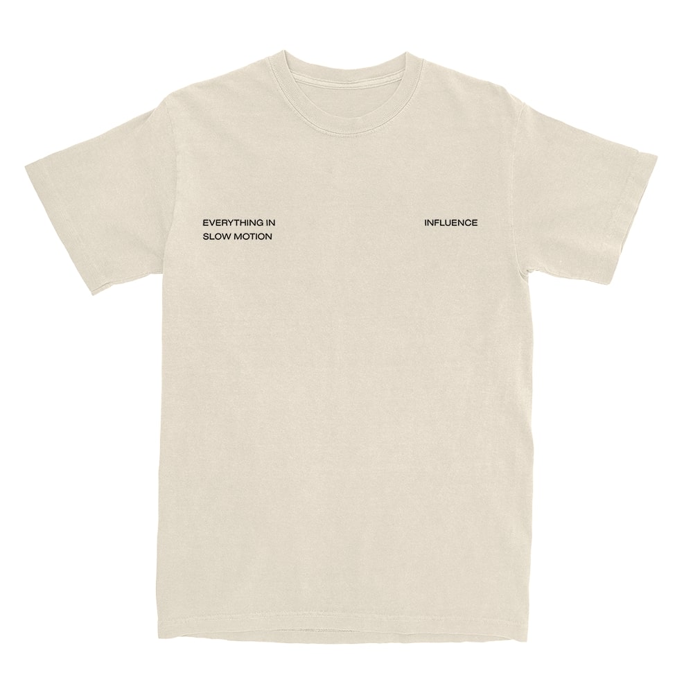 Beige t-shirt from Everything In Slow Motion featuring minimalist black text—“EVERYTHING IN SLOW MOTION” on the left chest, “INFLUENCE” on the right—showcasing a simple, Pacific-inspired design.